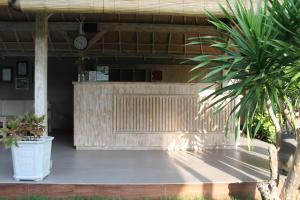 een patio met 2 palmbomen en een klok bij Green D'Mel Luxury Homestay in Nusa Dua