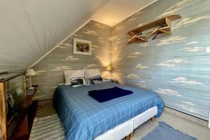 una camera da letto con un letto blu con nuvole dipinte sul muro di Holiday home near large beach a Quiberon
