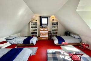 una camera mansardata con 2 letti e un tappeto rosso di Holiday home near large beach a Quiberon