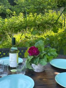 una botella de vino y una flor sobre una mesa de madera en Apartament w Złotym Stoku Przystanek Las en Złoty Stok