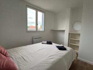 1 dormitorio con 1 cama con 2 toallas en Appartement à 4 min du métro, en Saint-Genis-Laval