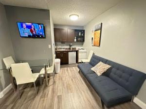 uma sala de estar com um sofá azul e uma cozinha em Sheridan Guesthouse em Dania Beach