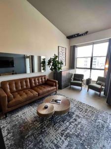 a living room with a leather couch and a table at San Diego Gaslamp Loft Getaway in San Diego