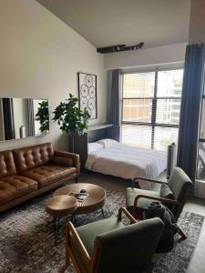 a living room with a couch and a bed at San Diego Gaslamp Loft Getaway in San Diego