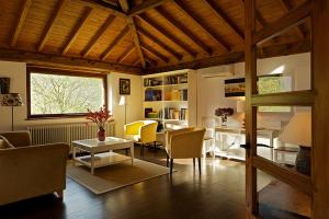 Una sala de estar con un sofá y sillas y una mesa. en Hotel Rural Casa de la Veiga, en San Esteban