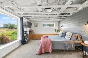 ein Schlafzimmer mit einem Bett und einem großen Fenster in der Unterkunft The River Box - Luxury Container Home - views and Hot Tub in Yakima