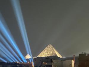 una imagen de las pirámides de Giza de noche en Nefertari pyramids inn, en El Cairo