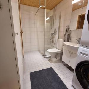 a white bathroom with a toilet and a sink at Moderni kaksio keskustassa, oma sauna! in Uusikaupunki
