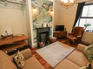 a living room with a couch and a fireplace at Emerald Cottage in Keighley
