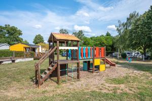 a playground with a wooden play structure in a park at Camping de Saverne in Saverne