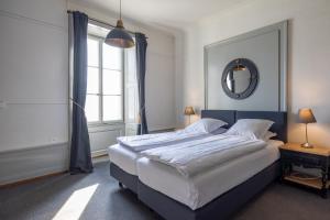 a bedroom with a large bed and a mirror at Vevey Hotel & Guesthouse in Vevey +42 photos