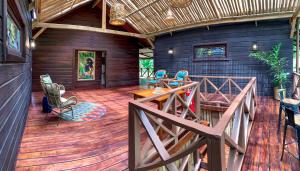 un ampio terrazzo con tavolo e sedie su una casa di The Lodge at Punta Rica- Hilltop Eco-Lodge with Views & Pool a Bastimentos