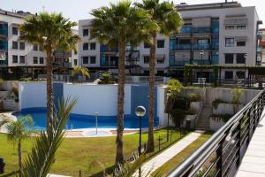 un balcón con palmeras y una piscina en La Bahia - Gelijkvloers appartement en Santa Pola