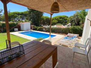 a patio with a table and chairs and a swimming pool at Villa Zen in Albufeira