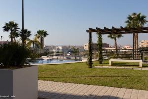 un parque con banco y cenador en La Bahia - Gelijkvloers appartement, en Santa Pola