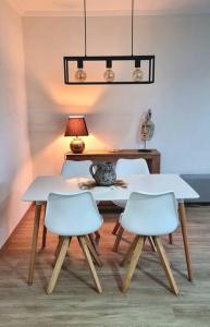 mesa y 2 sillas en una habitación con lámpara en La Bahia - Gelijkvloers appartement en Santa Pola