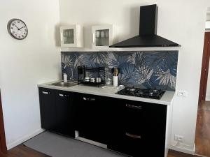 a kitchen with a stove and a clock on a wall at Podere Venanzio in Lido di Camaiore