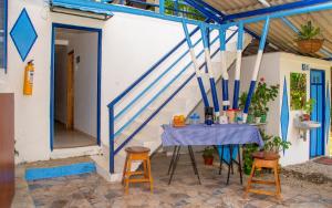 une maison avec une table bleue et des tabourets dans l'établissement Secretos del Eden, à Ruiosucio