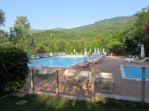 ein Swimmingpool mit Stühlen und Sonnenschirmen in der Unterkunft Albergo Lago Verde in Pennabilli