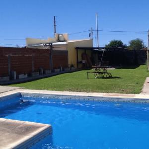 een blauw zwembad met een picknicktafel in een tuin bij Ruka Baradero in Baradero