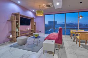 City Express Plus by Marriott Mundo E في مدينة ميكسيكو: غرفة معيشة مع أريكة حمراء وطاولة