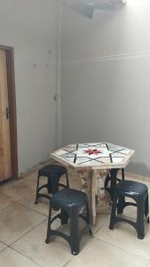 a table with four stools in a room at Sua casa completa em Viçosa do Ceará in Viçosa do Ceará