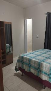 ヴィソザ・ド・セアラにあるSua casa completa em Viçosa do Cearáのベッドルーム1室(ベッド1台付)、スライド式ガラスドアが備わります。