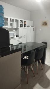 uma cozinha com uma mesa com cadeiras e um frigorífico em Sua casa completa em Viçosa do Ceará em Viçosa do Ceará