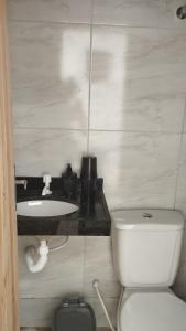 a bathroom with a white toilet and a sink at Sua casa completa em Viçosa do Ceará in Viçosa do Ceará