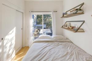 a white bedroom with a bed and a window at Stylish Austin Home with Hot Tub 3 Mi to Downtown! in Austin