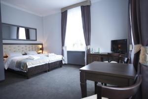 Una habitación de hotel con una cama, un escritorio y una mesa. en Villa Elizabeth, en Bolków