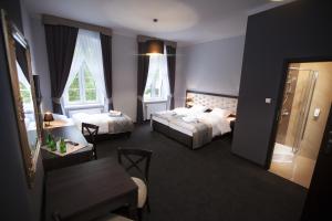 a hotel room with two beds and a table at Villa Elizabeth in Bolków