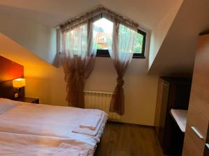 sypialnia z łóżkiem i oknem z zasłonami w obiekcie 7 apartments in Alexander complex w mieście Bansko