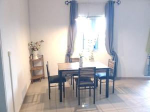 a dining room with a wooden table and chairs at Appart meublé le Dakota in Yaoundé