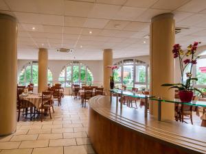 a restaurant with tables and chairs and a bar at Hotel Saint Georges Lourdes in Lourdes