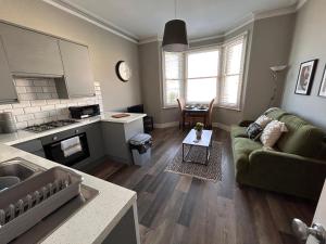 a living room with a couch and a table at Brighton City Flat Perfect for long stays in Brighton & Hove