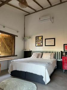 um quarto com uma cama grande e uma cadeira vermelha em Casa Chão em Prado