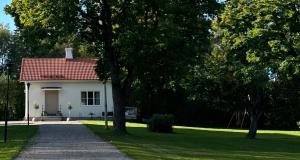 une maison blanche avec un toit rouge et une allée. dans l'établissement Pastors Prästgården, à Norberg
