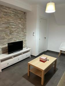 a living room with a tv and a coffee table at Casa Rosa1 in Valle de Abdalagís