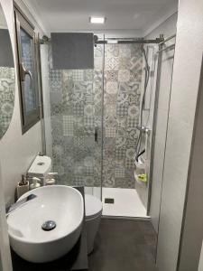 uma casa de banho com um chuveiro, um WC e um lavatório. em Apartamento ROSA em Valle de Abdalagís