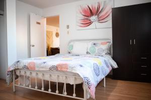 1 dormitorio con 1 cama con una flor rosa en la pared en Logis du Bonheur, en Rouyn