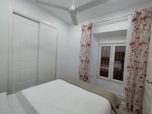 una camera bianca con un letto e una finestra di Apartamento Santa María ad Arcos de la Frontera