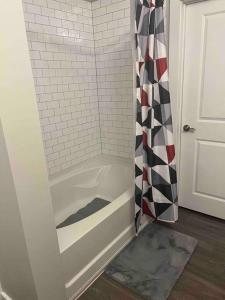 eine Dusche mit einem schwarzen und weißen Duschvorhang in der Unterkunft Luxury Home away from home ! in Franklin