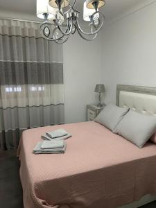 a bedroom with a bed with a chandelier at Casa Rosa1 in Valle de Abdalagís +17 photos