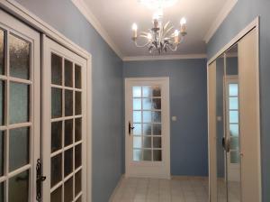 un couloir avec une porte et un lustre dans l'établissement Gite du Moulin, à Oignies