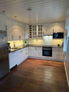 a large kitchen with white cabinets and a wooden floor at Aurlandsfjord Panorama in Aurland