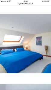 uma grande cama azul num quarto branco em Executive Serviced apartments 2 em Forfar