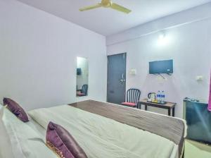- une chambre avec un grand lit et un ventilateur de plafond dans l'établissement Baga Beach Exotica, à Baga