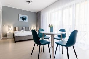 a dining room with a table and chairs and a bed at Tower Apartments in Cluj-Napoca