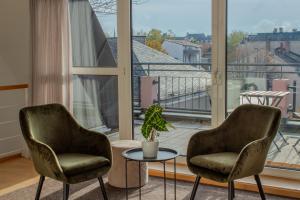 two chairs and a table in front of a large window at Penthouse-Maisonette - City Center, Highspeed Internet, Garage in Worms